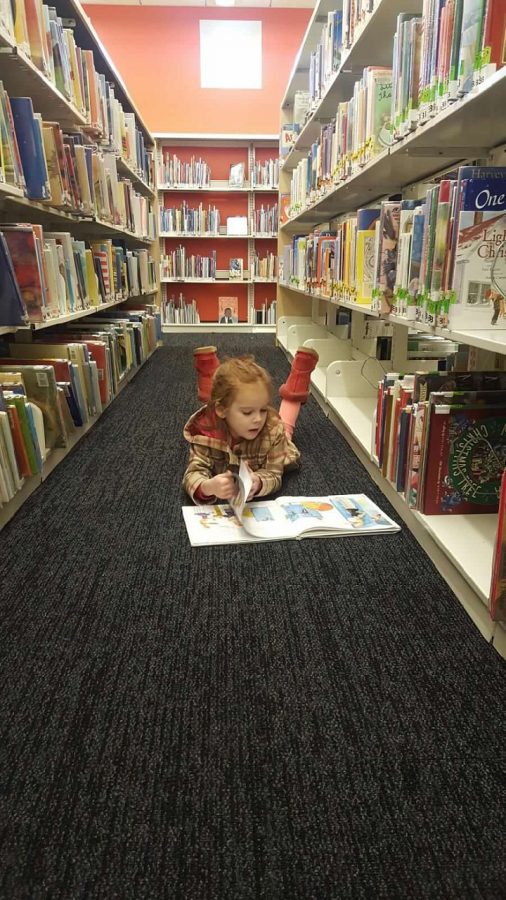 Chloe Crowl, kindergartener at Smith Elementary enjoying a book at the library.  