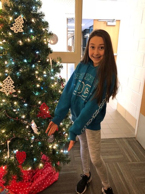Viviana Buzzelli poses by the Christmas tree in the counseling center. 