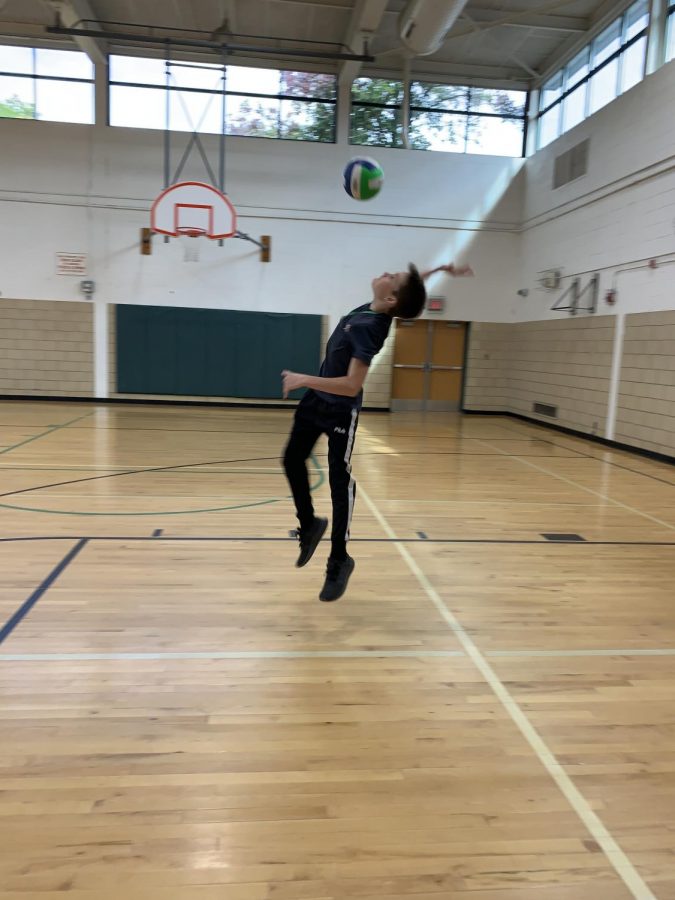 Luke Zajdel spikes a volleyball in the West gym.