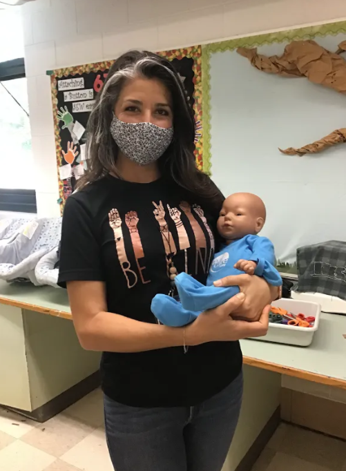 Mrs. Bazzi, LME teacher, holds baby doll used for Parenting Unit. 