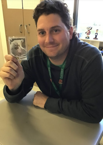Mr. Menzer posing with his grandfathers baseball card. 
